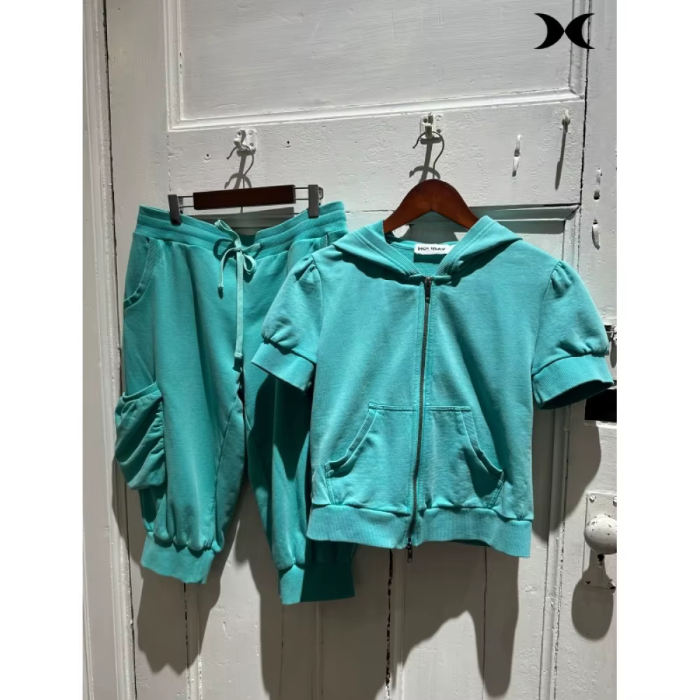 Ensemble de survêtement style streetwear américain pour femme : veste à capuche zippée à manches courtes et pantalon à sept poignées, couleur unie, style sport tendance.