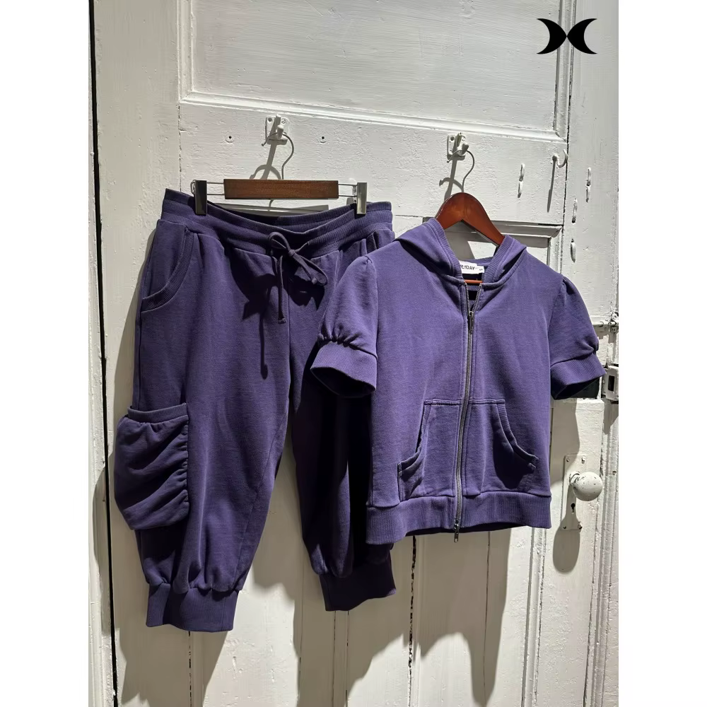Ensemble de survêtement style streetwear américain pour femme : veste à capuche zippée à manches courtes et pantalon à sept poignées, couleur unie, style sport tendance.